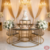 Gold semi-circular dessert station at wedding reception tiered cake macarons florals crystal chandeliers