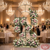 Gold arch window grid frame with white pink roses filling grid sections hotel wedding crystal chandeliers