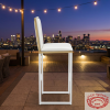 White gold frame bar stool at upscale hotel rooftop bar city skyline twilight